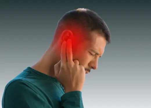 Un homme se tient les oreilles à cause des ses acouphènes