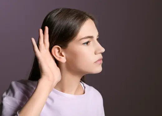 Une femme tend l'oreille à cause de son hypoacousie