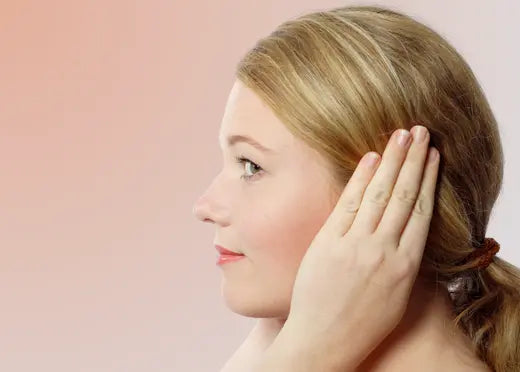 Une jeune femme qui se bouche les oreilles à cause de l'hyperacousie