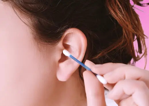 gros plan sur un coton tige près d'une oreille