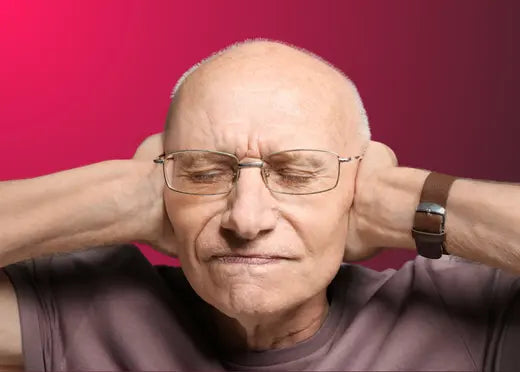 Un homme âgé se bouchant les oreilles avec les mains