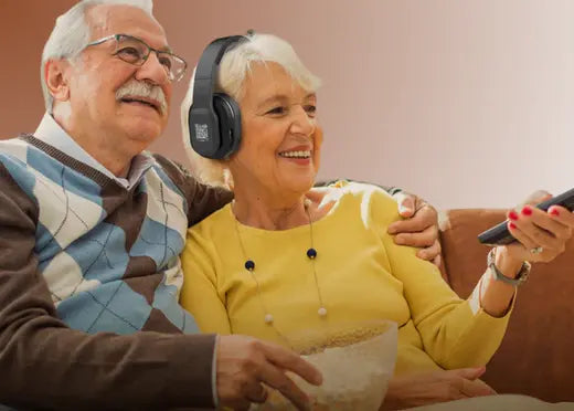 Un coupe de senior regardent la TV avec un casque amplificateur