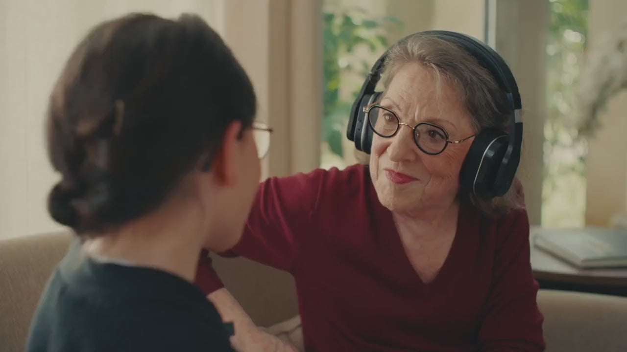 Une grand-mère équipée du casque Spokeo échange avec sa petite-fille, qui porte le micro