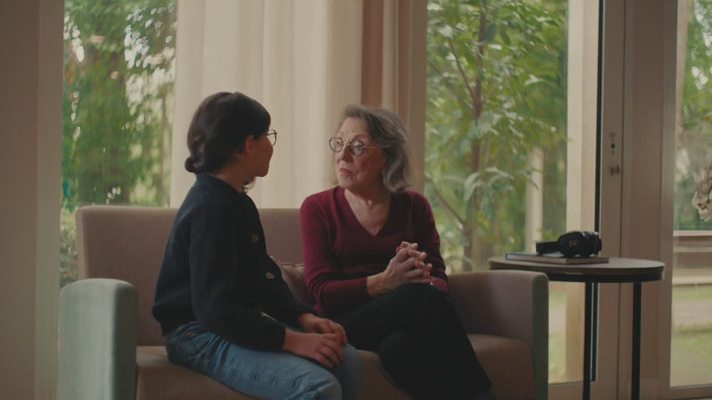 Une petite fille et sa grand-mère discutent sans problème grâce à l'assistant d'écoute Spokeo. 