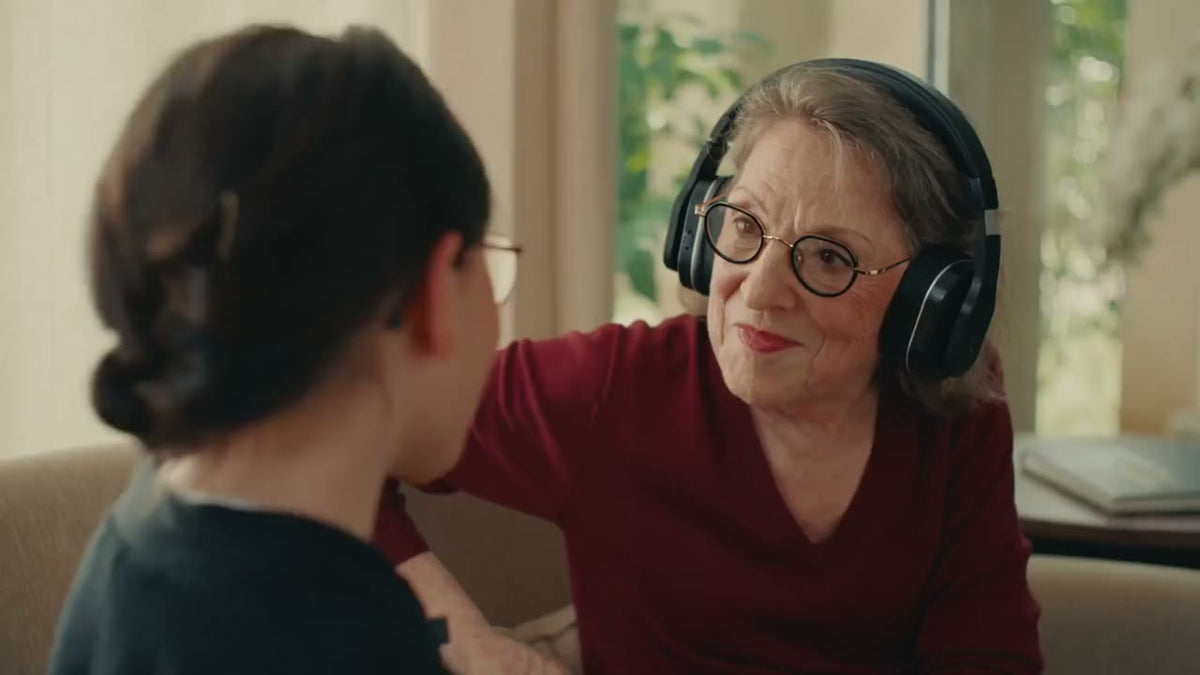 A grandmother wearing the Spokeo headset talks with her granddaughter, who wears the microphone